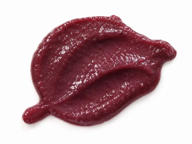 Close-up texture of thick natural plum puree on a white background