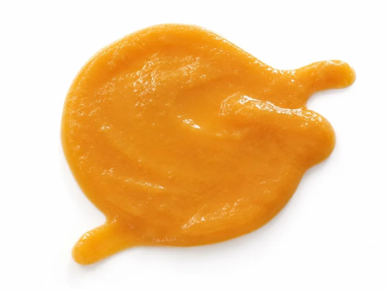 Smooth orange peach puree texture isolated on a white background